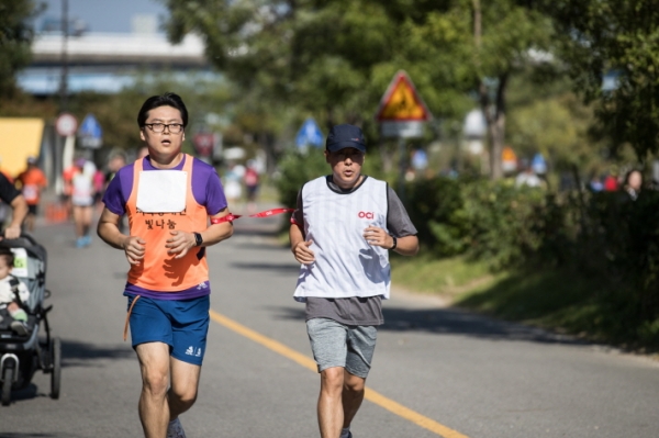 시각장애인 마라토너와 달리기 도우미인 OCI 직원이 함께 10km를 완주하고 있다. (사진=OCI)