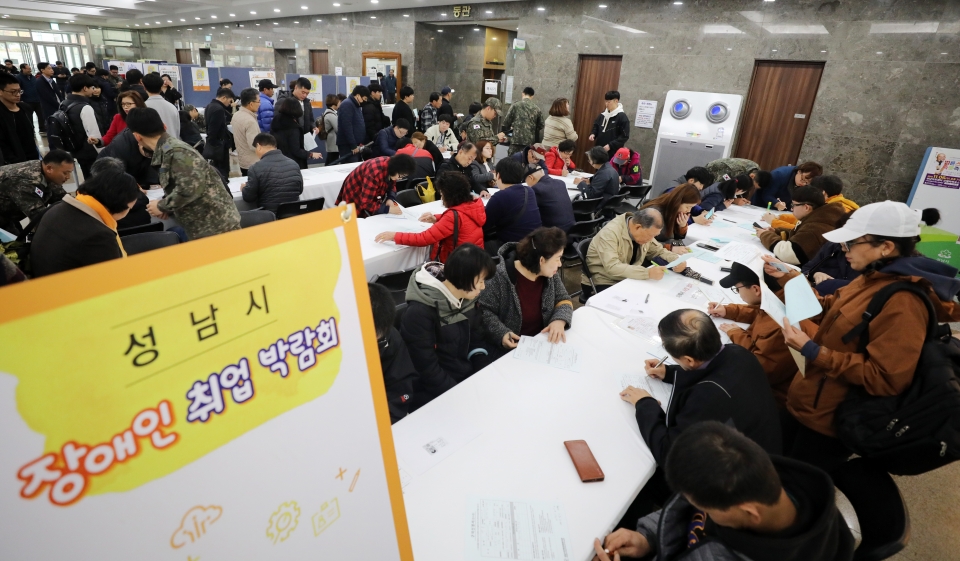 지난 11월 13일 오후 경기도 성남시청에서 열린 '성남시 장애인 취업 박람회'에서 구직자들이 일자리를 찾기 위해 이력서를 작성하는 모습.