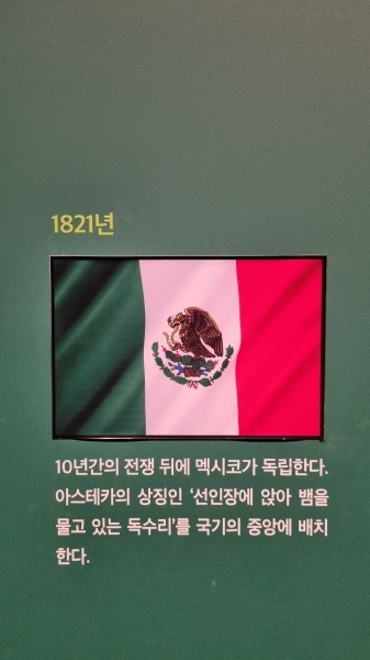 뱀을 물고 있는 독수리가 선인장 위에 앉아 있는 문양이 있는 멕시코 국기